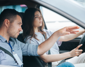 An Instructor guiding and a girl student behind the wheel